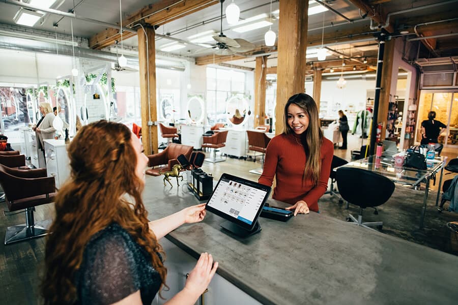 woman paying cashier in local business
